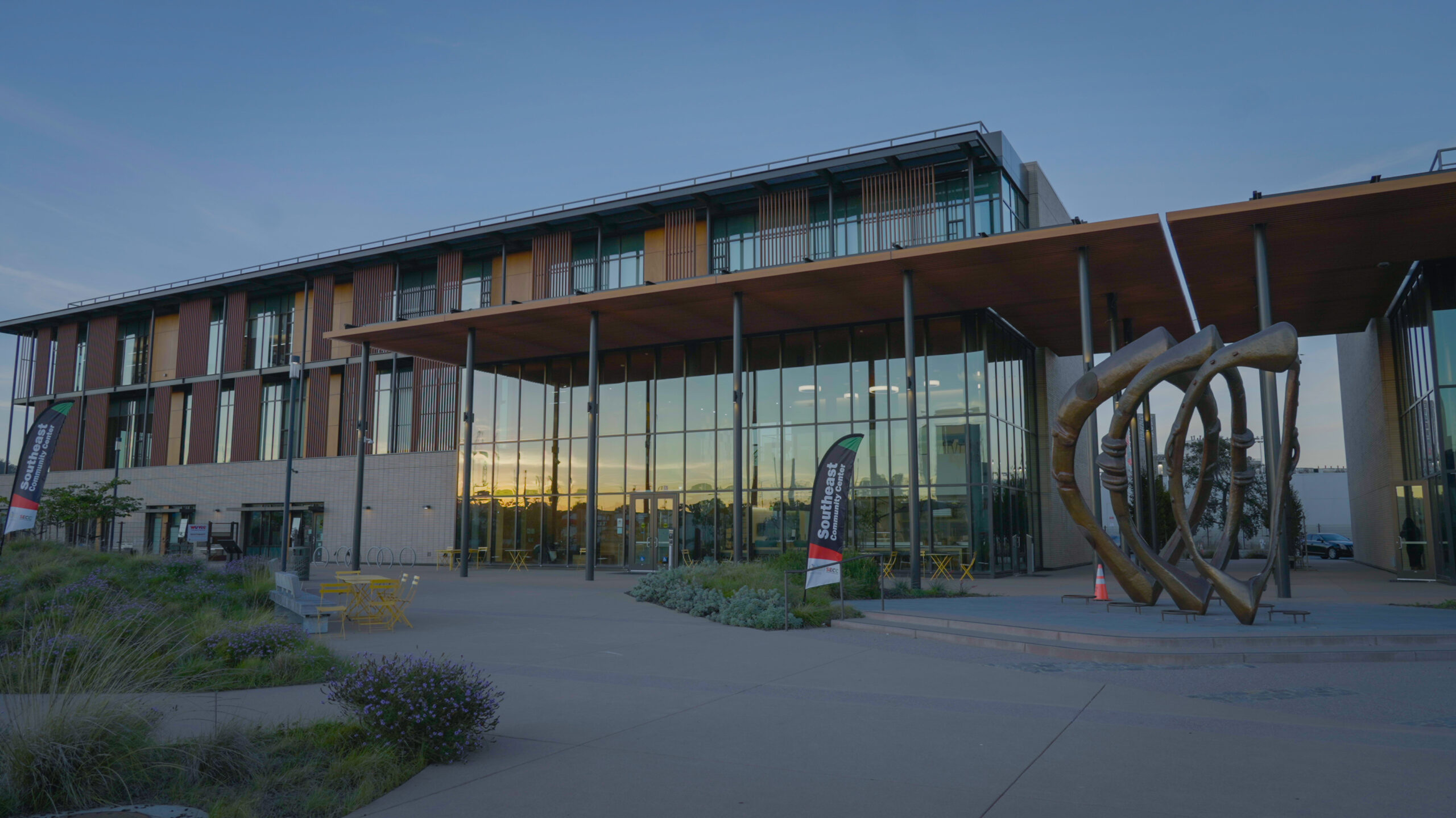 The Southeast Community Center at dusk. Sunset is reflected in the windows.